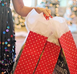 close-up of someone holding Christmas shopping bags